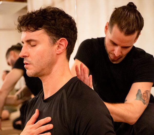 Paradigm Rhyme facilitator leading an in-office breathwork session with a team, warm natural light